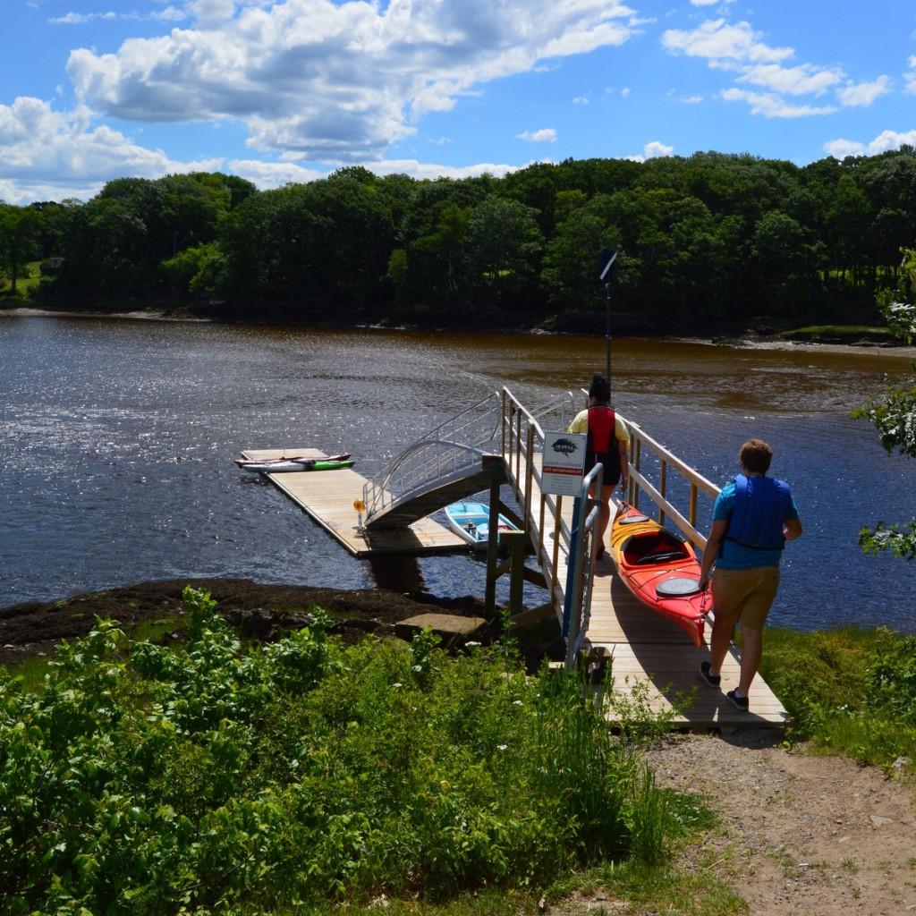 students launch kayaks from a dock