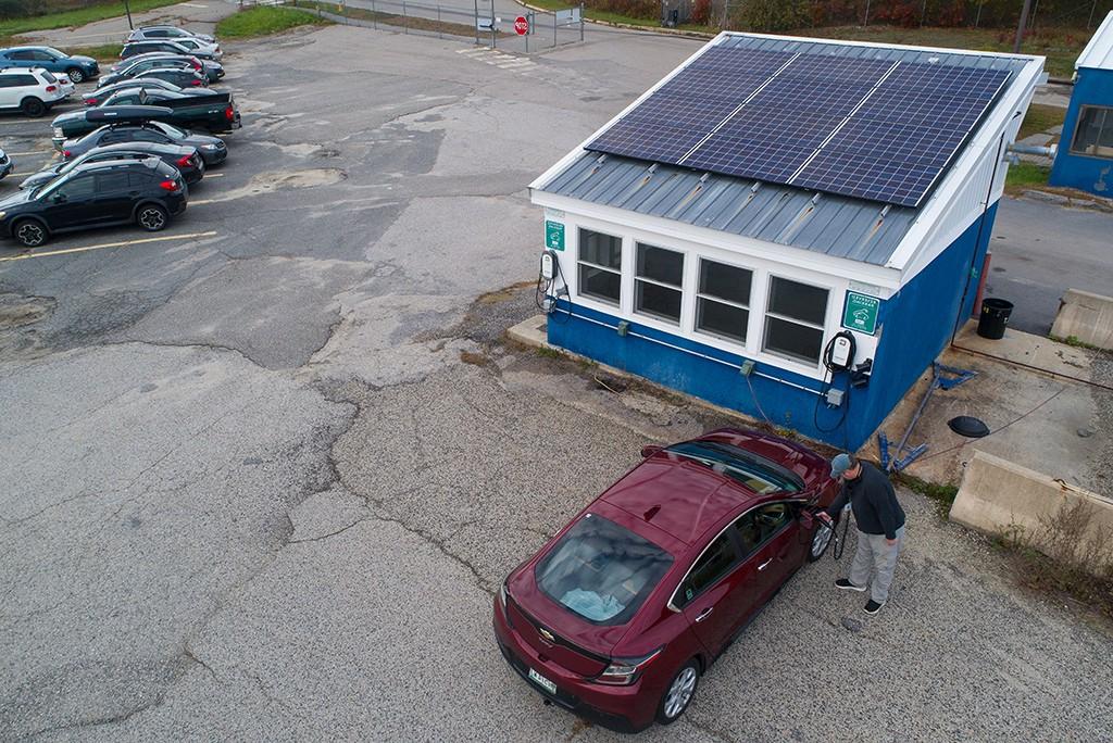 一名男子在波特兰校园的充电站给他的电动汽车充电