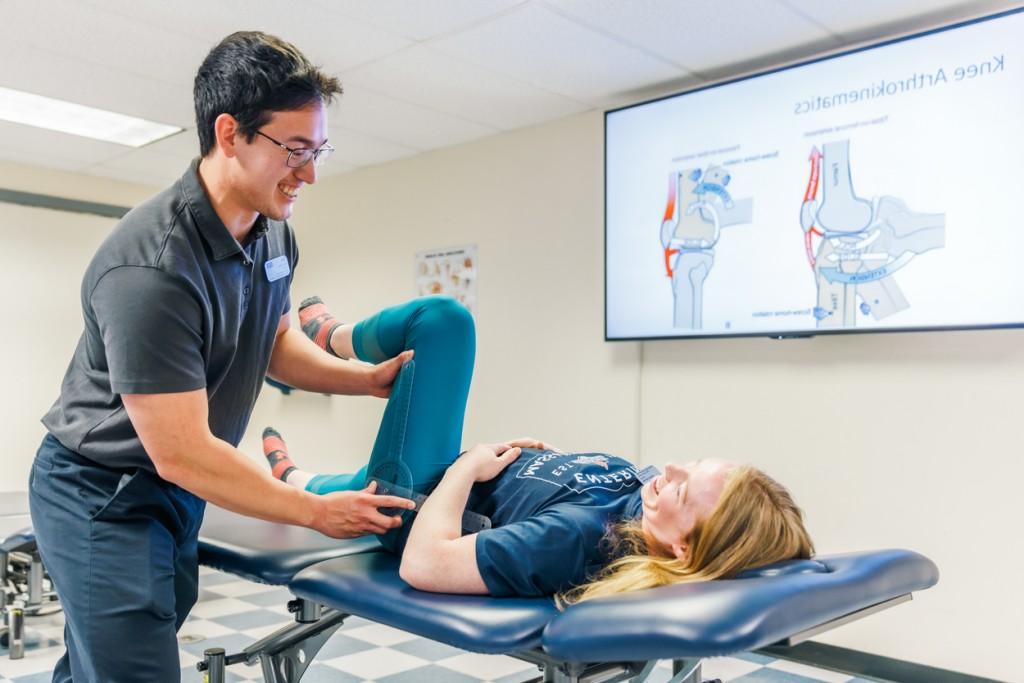 一位理疗专业的学生正在练习检查病人的腿部活动能力