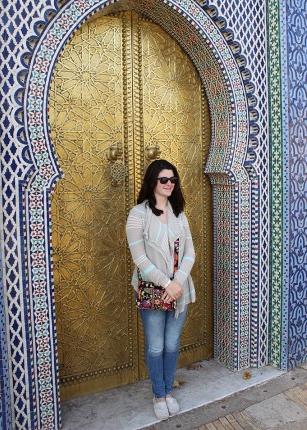 摩洛哥，一名学生站在一扇镀金的门前