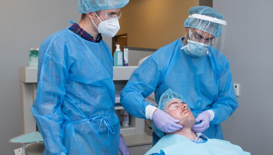 作为跨专业教育的一部分，医师助理学生协助牙科医学学生给病人进行检查