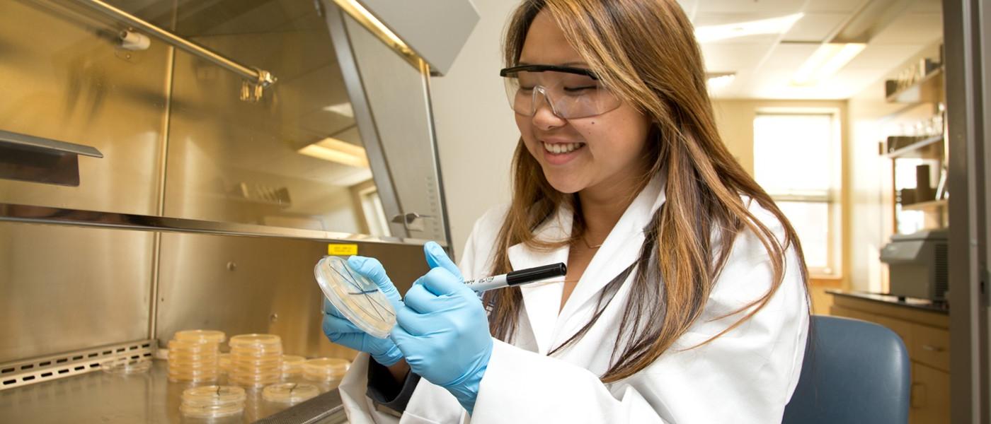 A female science student holds a petri dish
