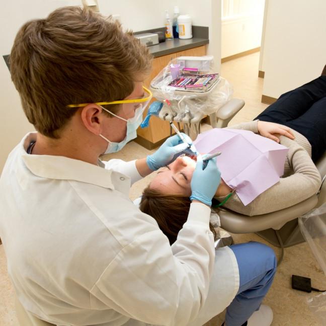 一名学生正在给病人清洁牙齿